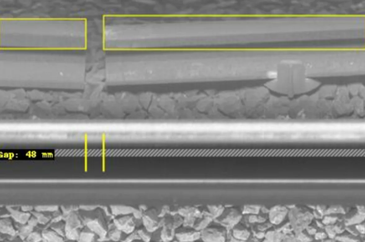 Close-up line-scanning image of conductor rail showing ramp end gap measurement with yellow detection boxes and measurement markers.