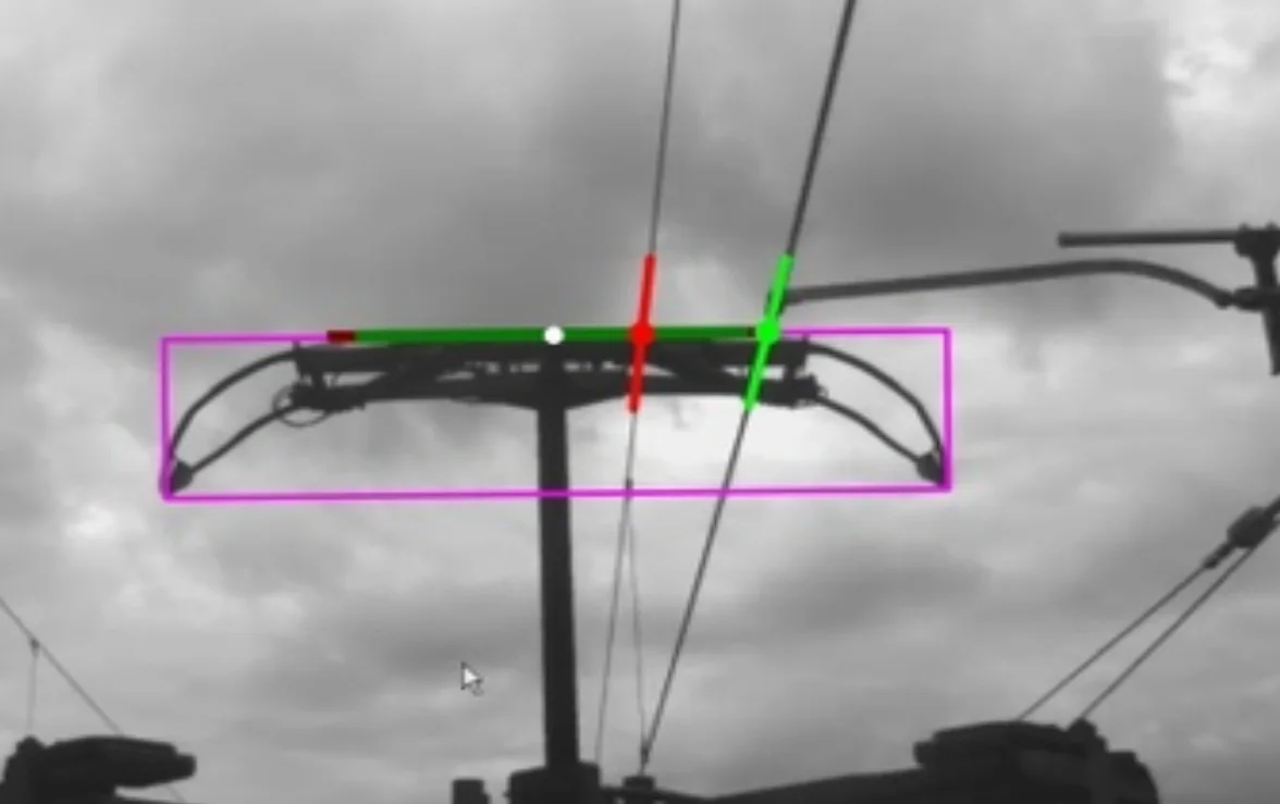 Pantograph camera view showing overhead line wire with height and stagger measurement overlays in green and red.